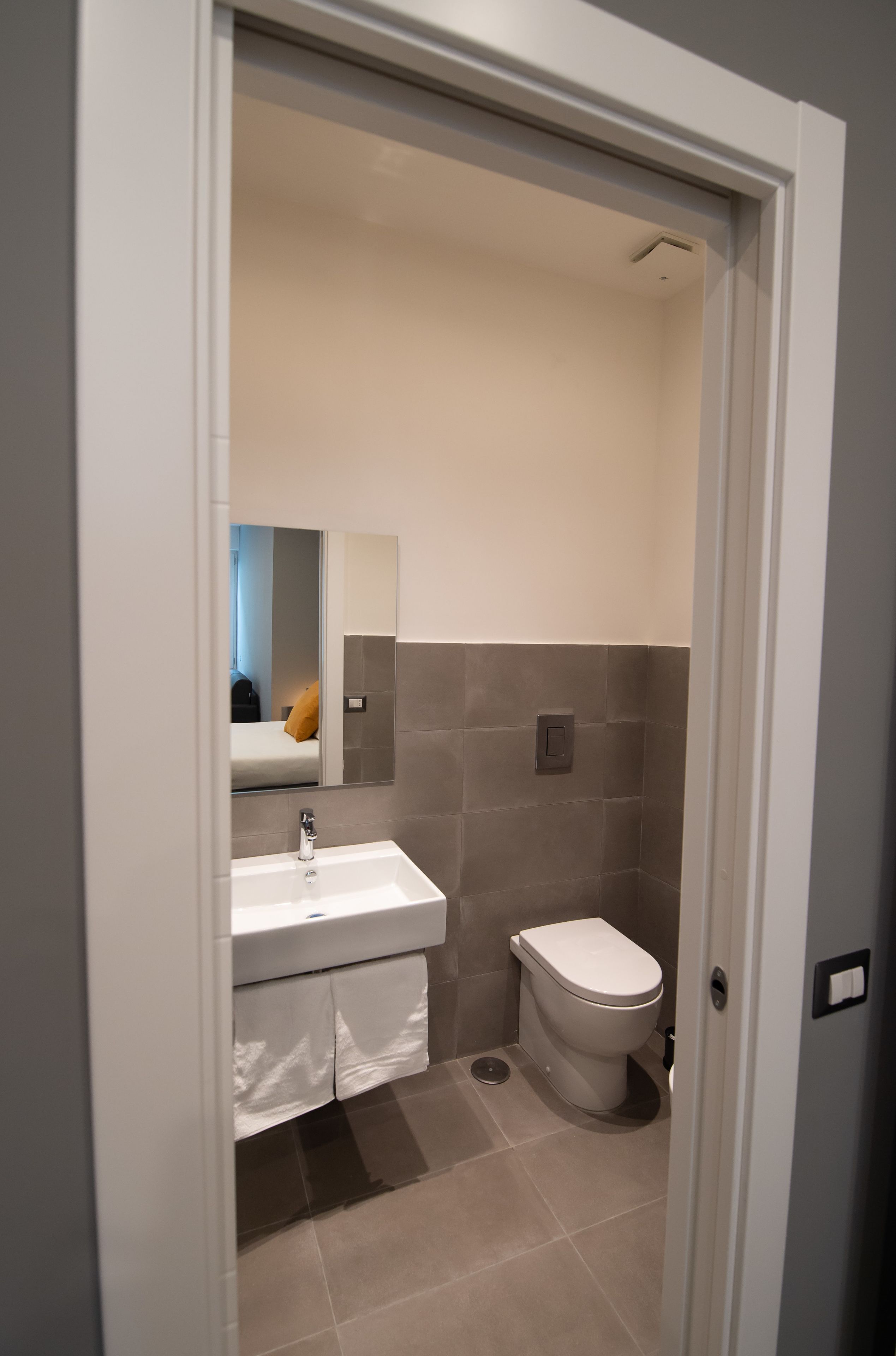 Un baño pequeño con lavamanos blanco, inodoro y espejo.