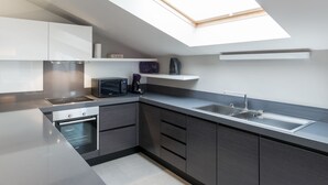 A modern kitchen with a skylight, built-in oven, and stainless steel appliances. - Four Stars Aparthotel (Luxembourg City)