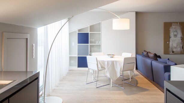 A modern interior with a dining area, a sofa, and a large window. - Four Stars Aparthotel (Luxembourg City)