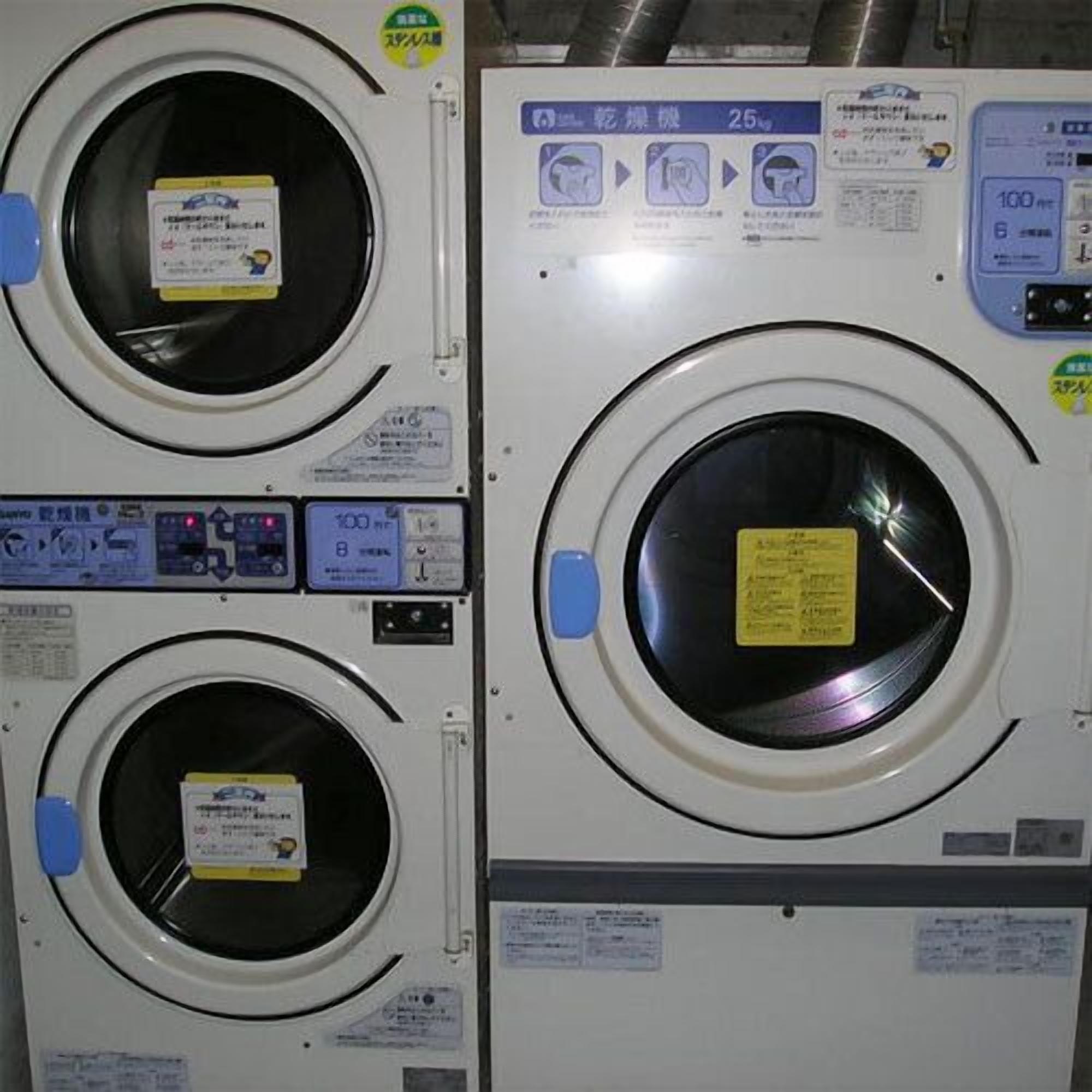 Two front-loading washing machines with control panels and instruction labels.