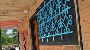 A wooden building with a metal gate and a red door. - Paraiso Lounge Santa Marta (Santa Marta)