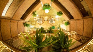 A spacious atrium with high ceilings, a central seating area, and decorative plants.