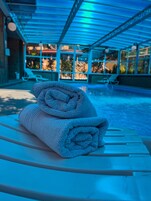 Una piscina techada, sillones reclinables de piscina