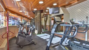 A gym with stationary bikes, treadmills, and weight machines.