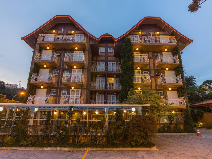 A multi-story hotel with balconies, a covered outdoor area, and a parking lot.