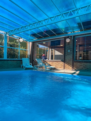 Una piscina cubierta, tumbonas