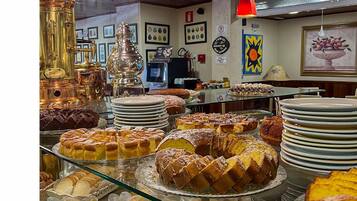 Un buffet proposant une variété de produits de boulangerie et de pâtisserie, présentés sur des étagères en verre.