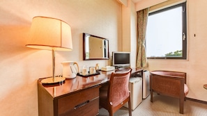 A hotel room with a desk, a chair, a lamp, a television, and a window with a view. - Newwellcity Miyazaki (Miyazaki)