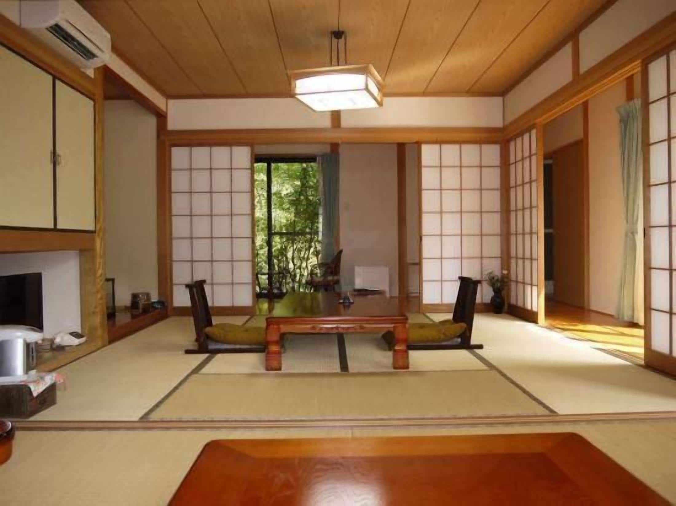 A traditional Japanese room with tatami flooring, a low wooden table, and sliding doors.