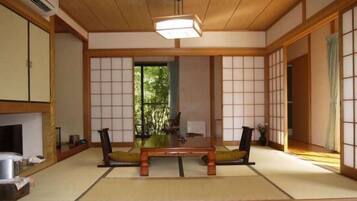 A traditional Japanese room with tatami flooring, a low wooden table, and sliding doors.