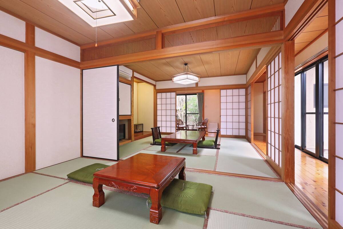 Ein traditioneller japanischer Raum mit Tatami-Böden, einem Holztisch und Schiebetüren.