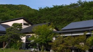 A residential area with houses, a parking lot, and a hillside. - Yamaga Hirayama Onsen Ryokan Kazokuyu Imamura (Yamaga)