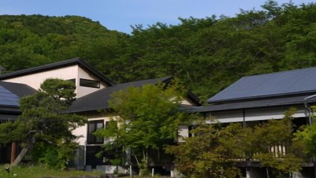 A residential area with houses, a parking lot, and a hillside.