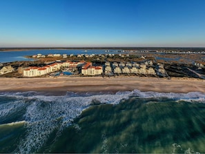 En kystferieby med villaer direkte ved stranden, en sandstrand og udsigt over havet.