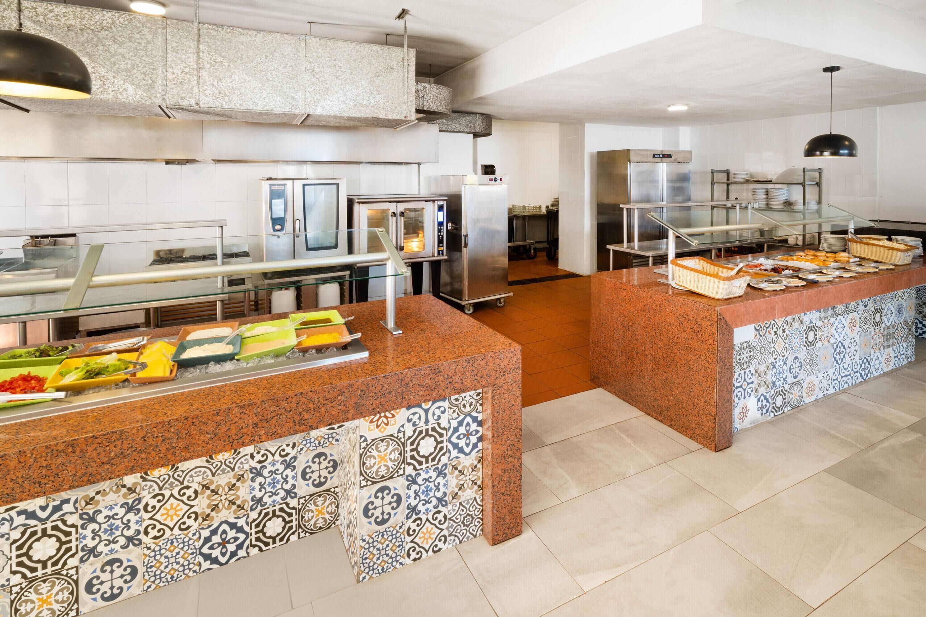 A buffet area with a variety of food items, a refrigerator, and a microwave.