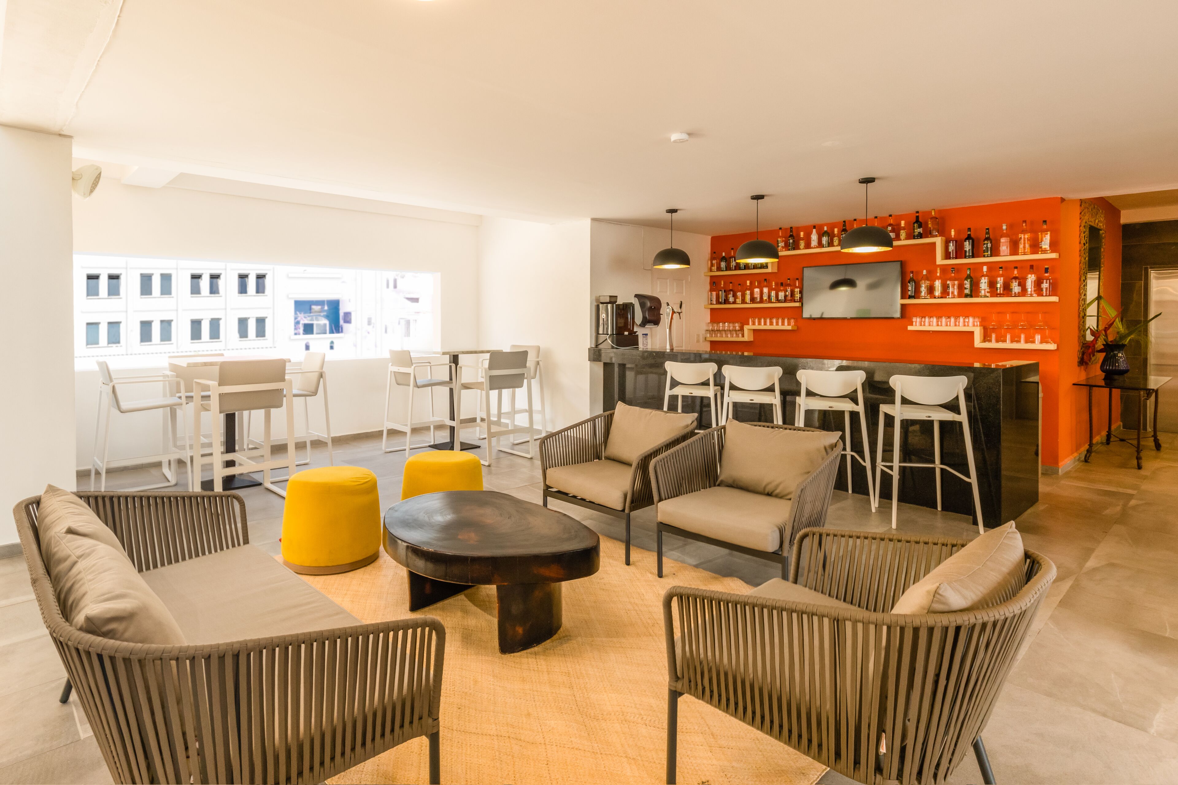 Un espacio moderno para relajarse con barra, asientos y vistas a la ciudad.