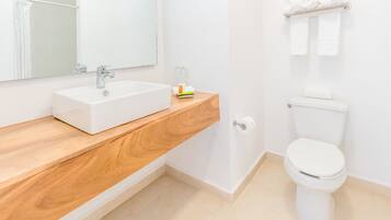 Ein modernes Badezimmer mit einem weißen Waschbecken, einem Holz-Waschtisch, einer Toilette und einem Handtuchhalter.