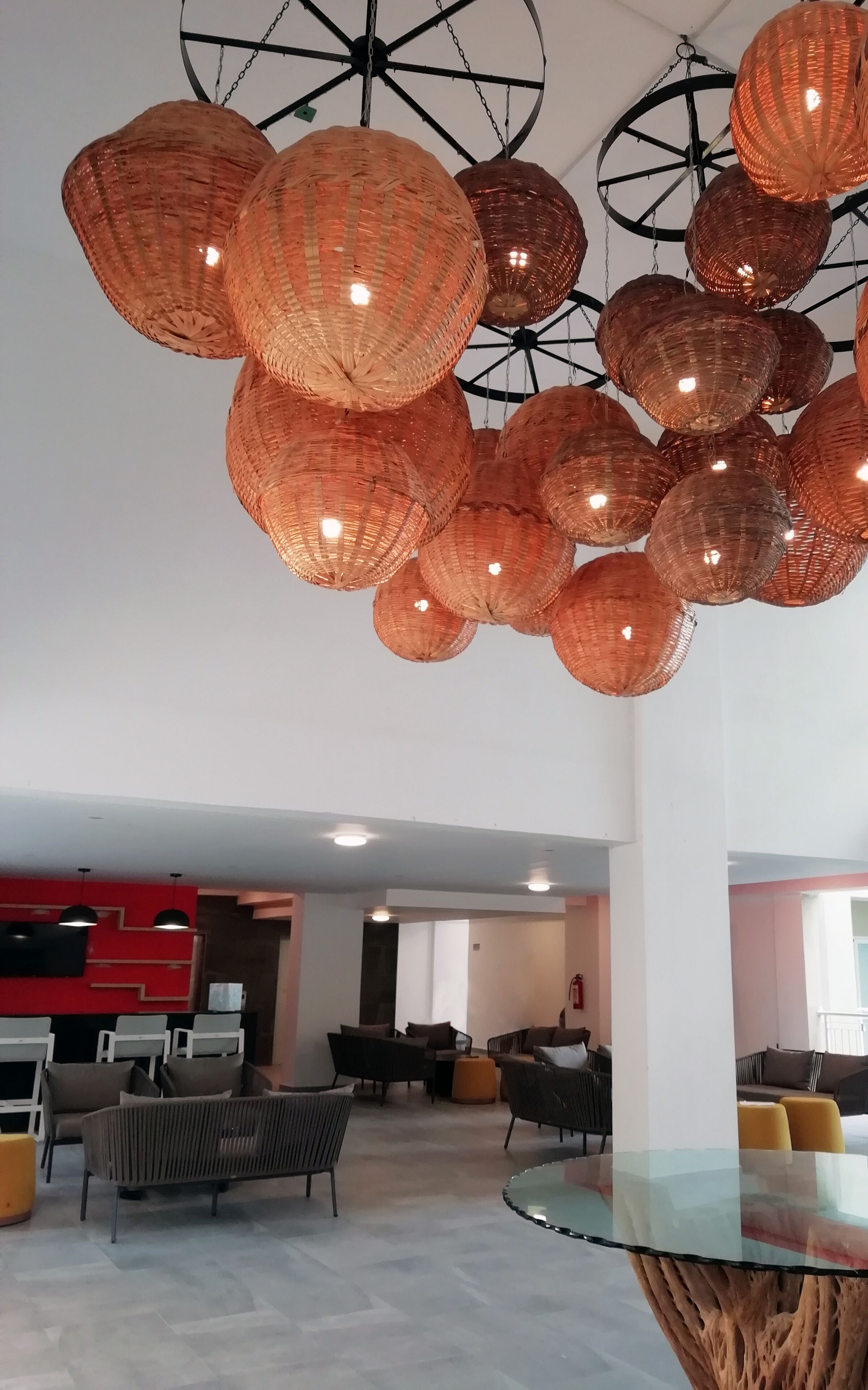 En rummelig lobby med moderne møbler, et bord med glasplade og en markant lampe.
