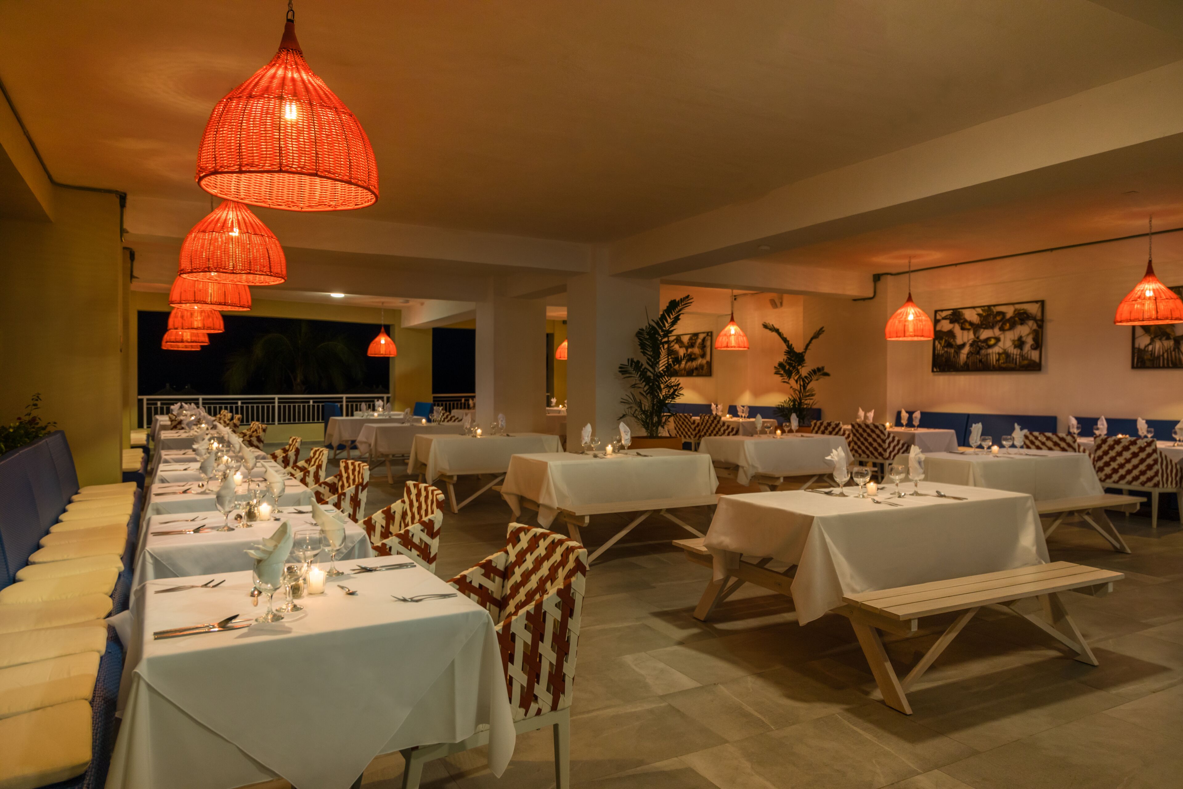 A restaurant with multiple tables set for dining, featuring a long counter and booths.