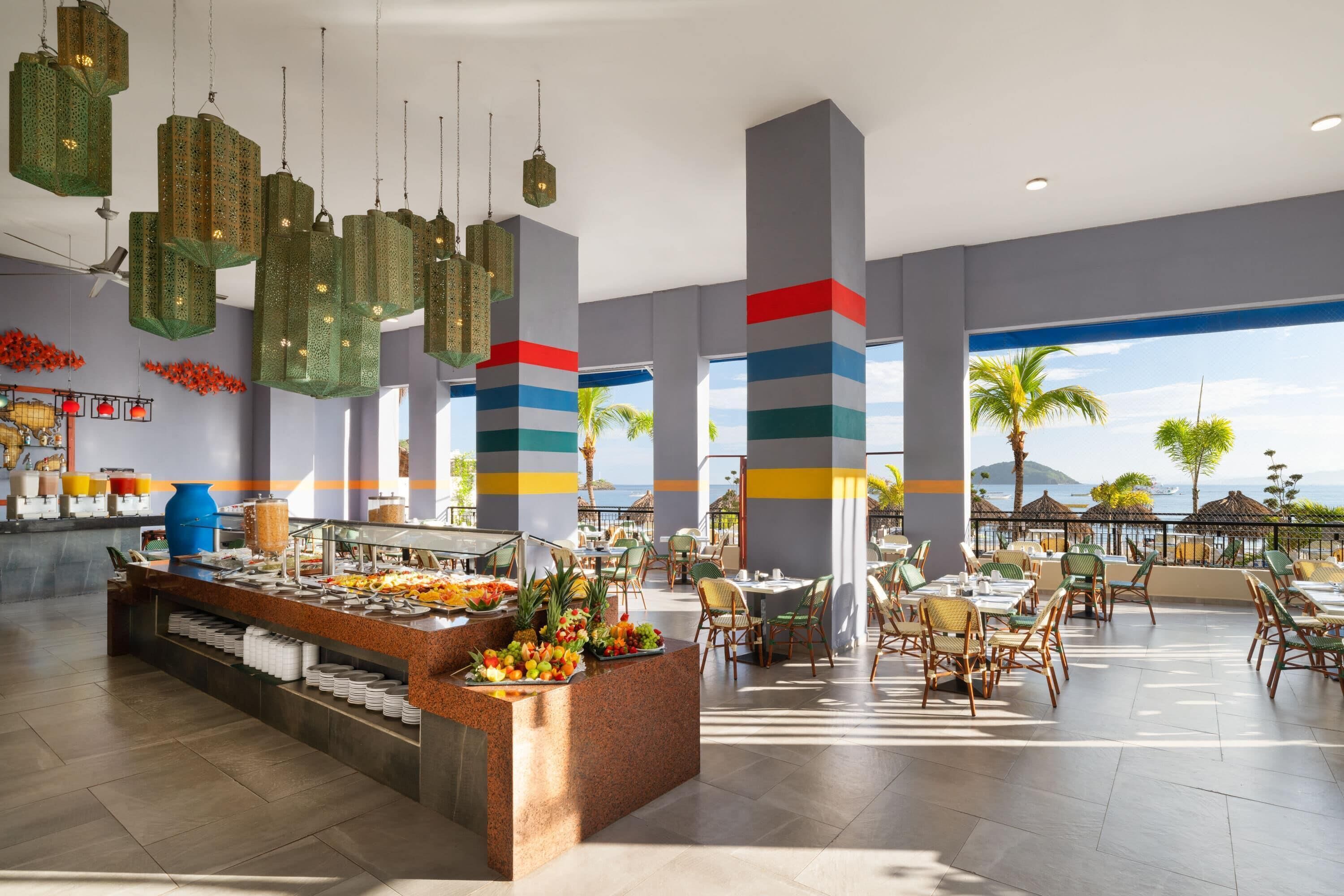 A hotel lobby with a buffet, seating area, and a view of the sea.