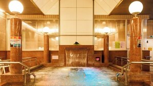 A hot spring bath with a central water feature, surrounded by marble walls and railings. - Tennen Onsen Relax Park Terume Kanazawa (Kanazawa)