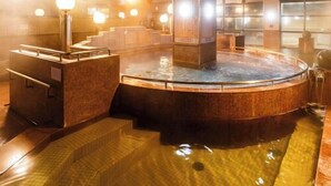 A hot spring bath area with steps leading into the water, a wooden bench, and a tiled wall. - Tennen Onsen Relax Park Terume Kanazawa (Kanazawa)