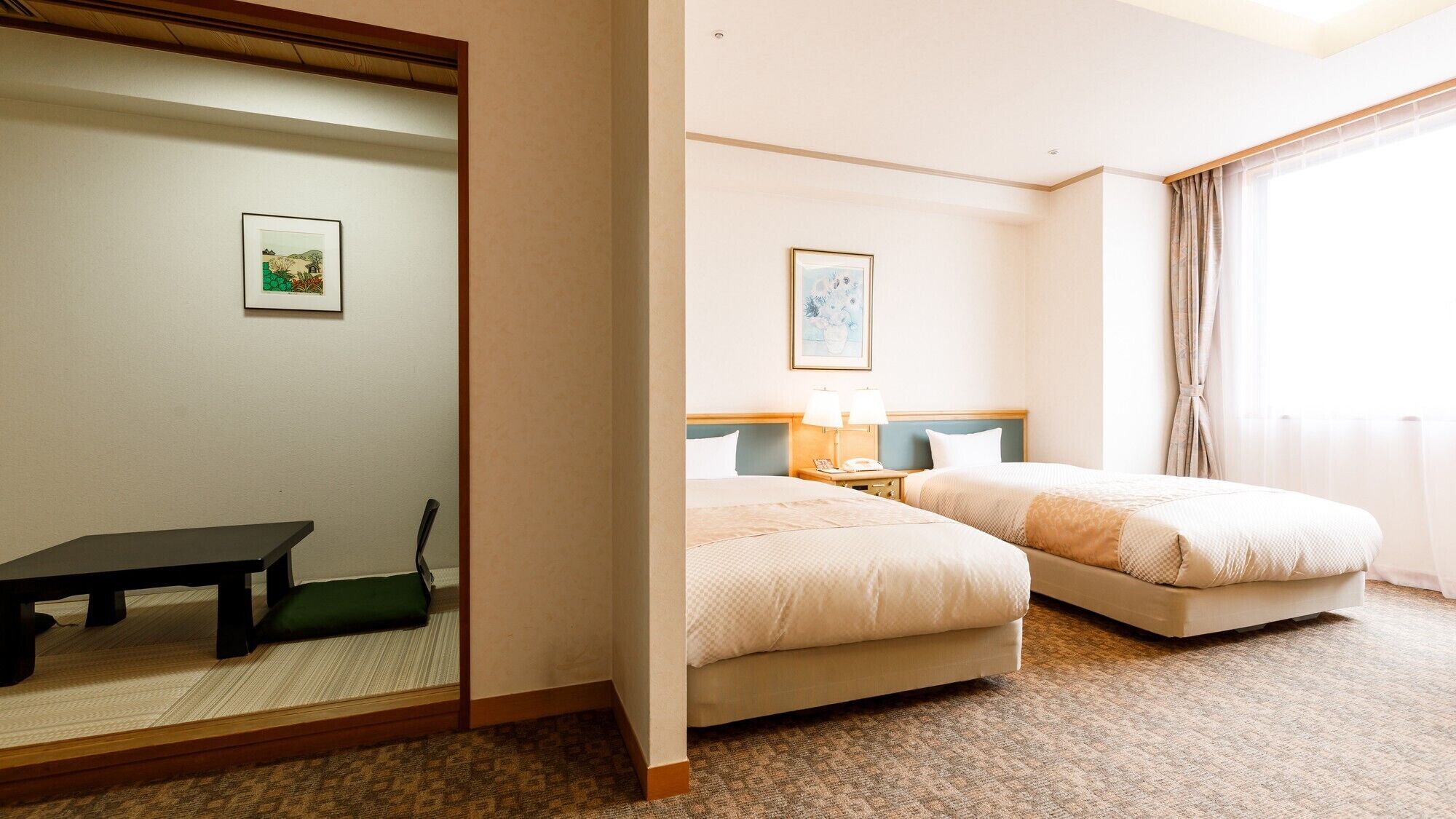 Habitación de hotel con dos camas, un escritorio, una silla, un espejo y un cuadro en la pared.