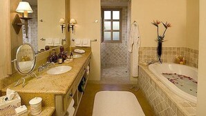A bathroom with a double sink, a large mirror, a bathtub with rose petals, and a shower area. - Esperanza Resort, PRIVATE POOL, JACUZZI PLUS 4 Bedroom, 4 1/2 Bath (Cabo San Lucas)