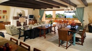 A spacious living area with a dining table, sofas, and a television. - Esperanza Resort, PRIVATE POOL, JACUZZI PLUS 4 Bedroom, 4 1/2 Bath (Cabo San Lucas)