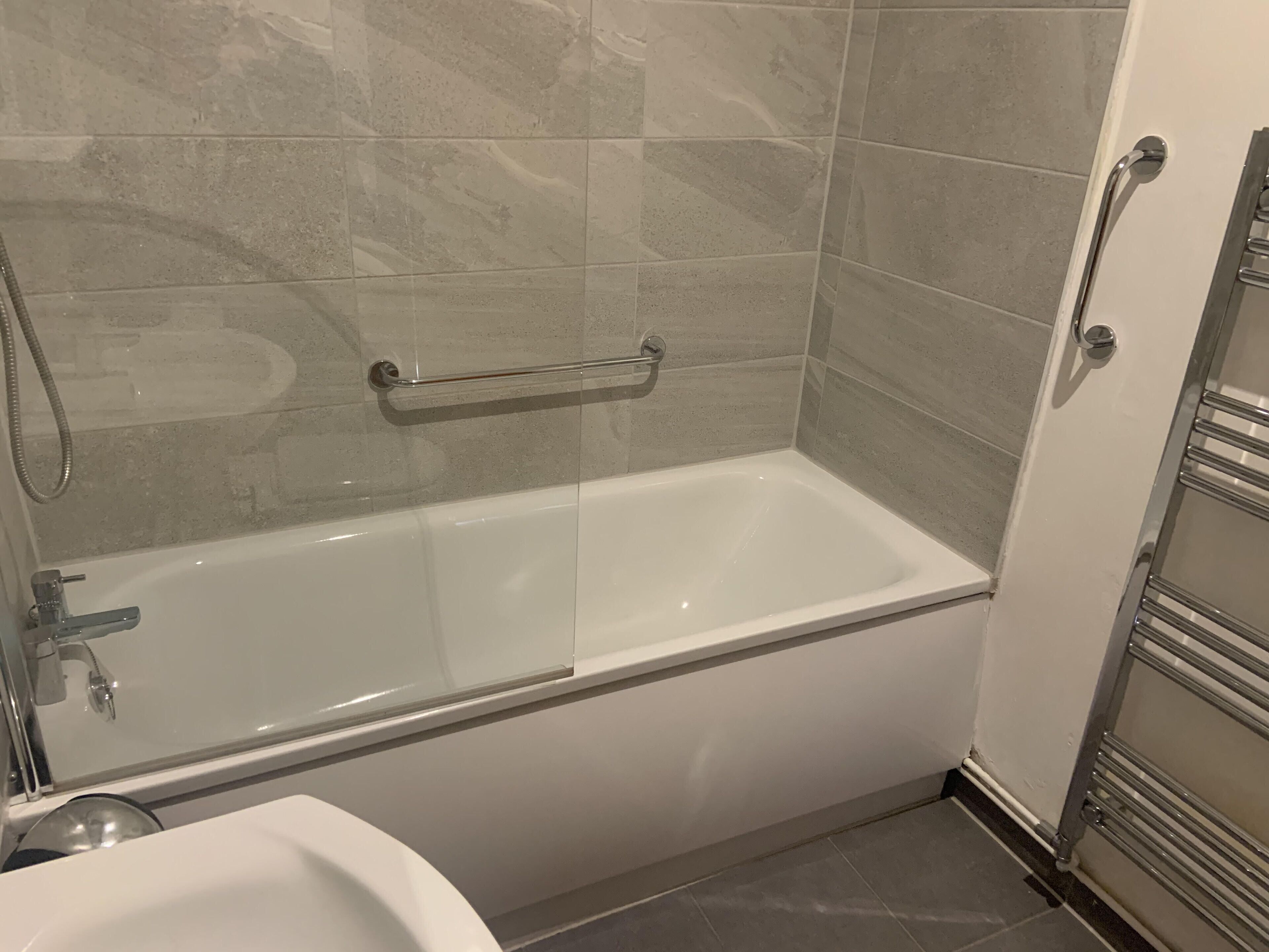 Une salle de bain moderne équipée d’une baignoire, d’une douche et de toilettes.