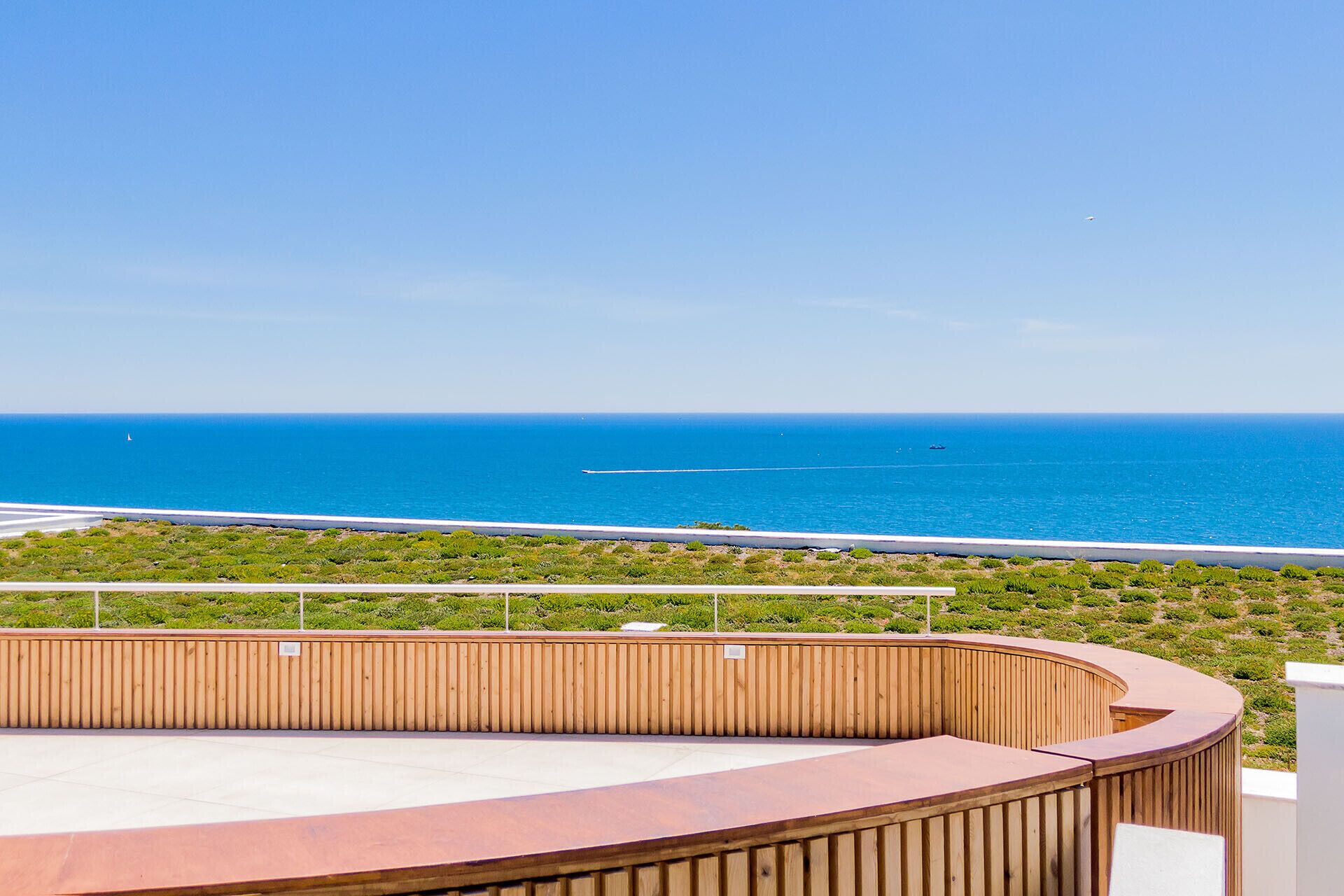 Een balkon met uitzicht op zee en een weg.
