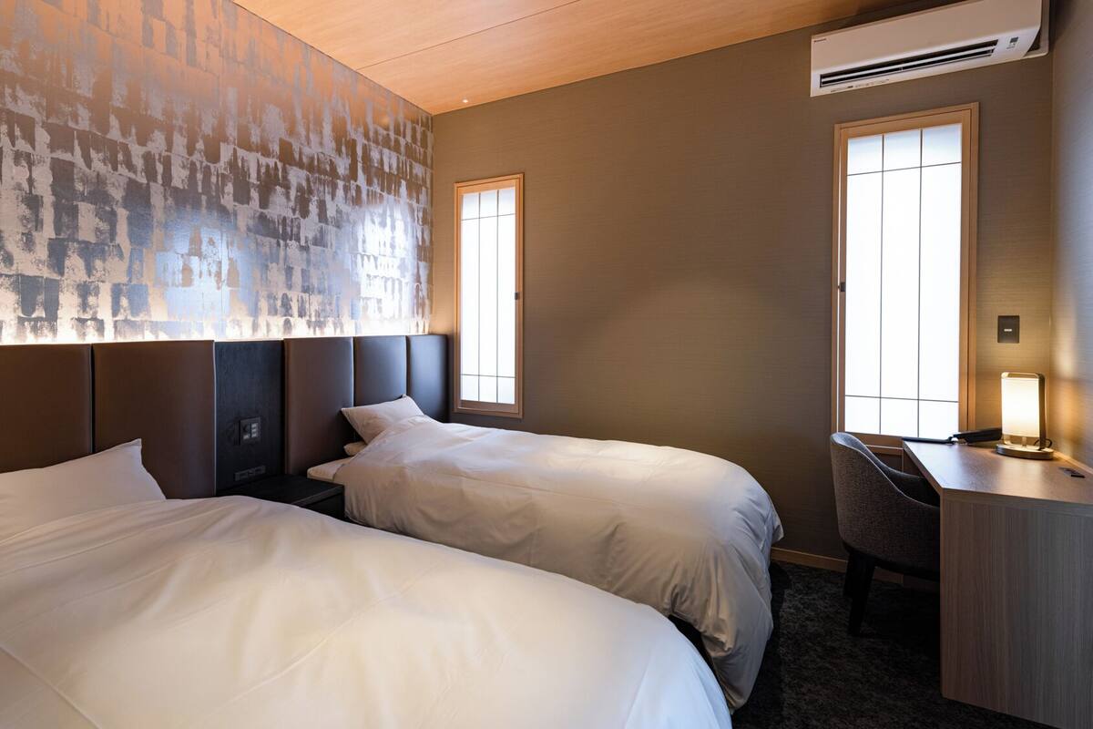 Una habitación de hotel con dos camas, un escritorio y una silla.
