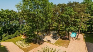Ein Park mit Schwimmbad, Bänken und einem Kiosk.