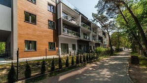 Ein mehrstöckiges Wohngebäude mit Backsteinfassade, Balkonen und einem gepflasterten Weg.
