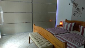 Une chambre à coucher avec un lit, un banc et une table de chevet avec une lampe.