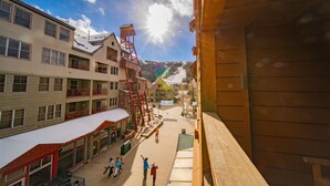 A hotel with multiple floors, balconies, and a ski slope in the background.