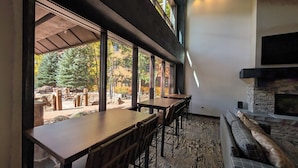 Un interno moderno con zona pranzo, ampie finestre e un camino in pietra.