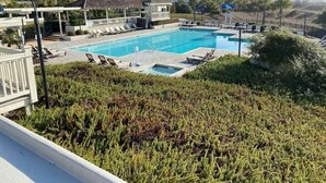 Zona de piscina hotelera con sillones de descanso y un pequeño pabellón.