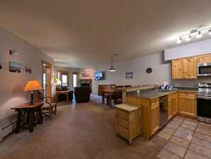 Una cocina amplia con armarios de madera, una isla central y un comedor con sillas y una mesa.