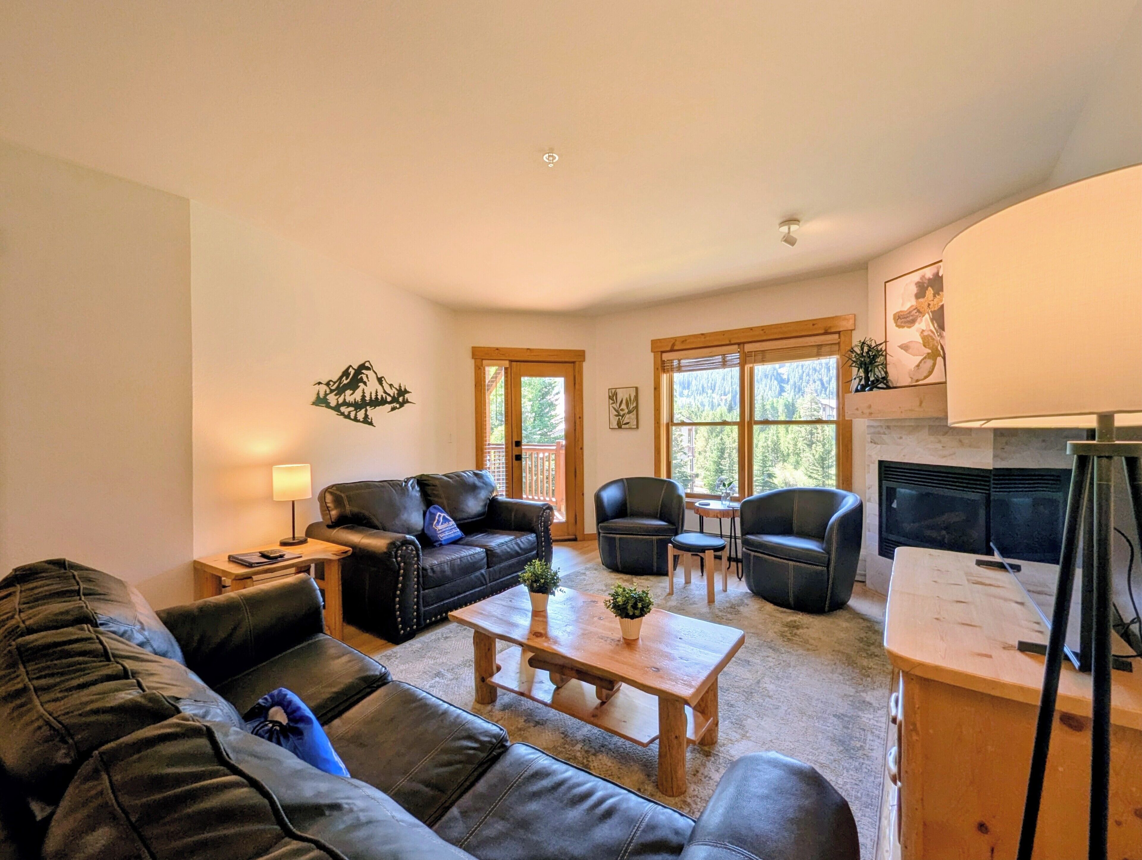 A living room with a sofa, chairs, a coffee table, and a fireplace.