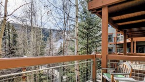 Un balcon avec vue sur une forêt et des montagnes.