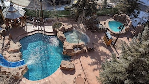 A swimming pool with multiple sections, surrounded by rock formations and seating areas. - Ultra-Luxury Penthouse | 100Yds to Slopes (Keystone)