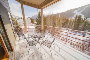 A balcony with metal chairs and a table, overlooking a snowy landscape with trees and mountains. - Family-Friendly | Walk to Lifts, Pool/Hot Tub (Keystone)