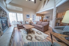 Cozy living room with a fireplace, comfortable seating area, and dining space.