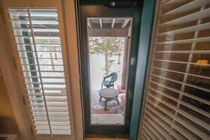 Puerta con vista a un patio que incluye una silla y una mesa.