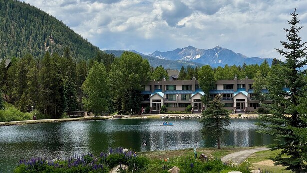 A lakeside lodge with multiple buildings, a dock, and a mountain backdrop. - Keystone Condo | Lake Views + Balcony + Pool (Keystone)