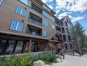 A multi-story building with balconies, a wooden facade, and a sign reading 'The Dakota 150'.