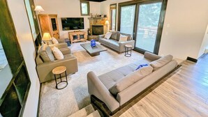 A modern living room with a fireplace, sofas, and a TV. - Modern Unit w/Pool & Hot Tub + 2 Parking Spots (Keystone)