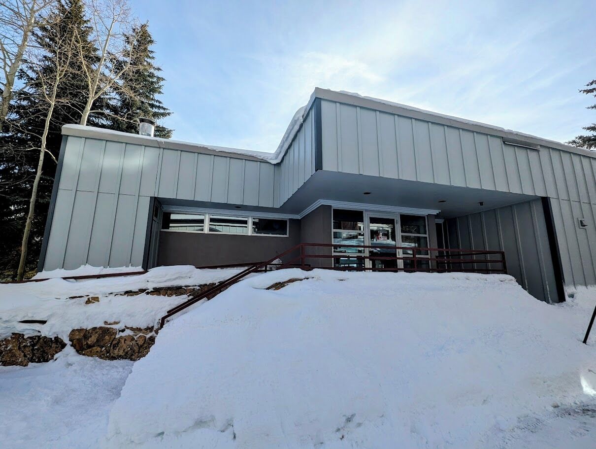 A modern building with a garage and a covered entrance.