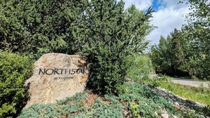 Una gran roca con la inscripción "NORTH STAR at Keystone", rodeada de abundante follaje y árboles.